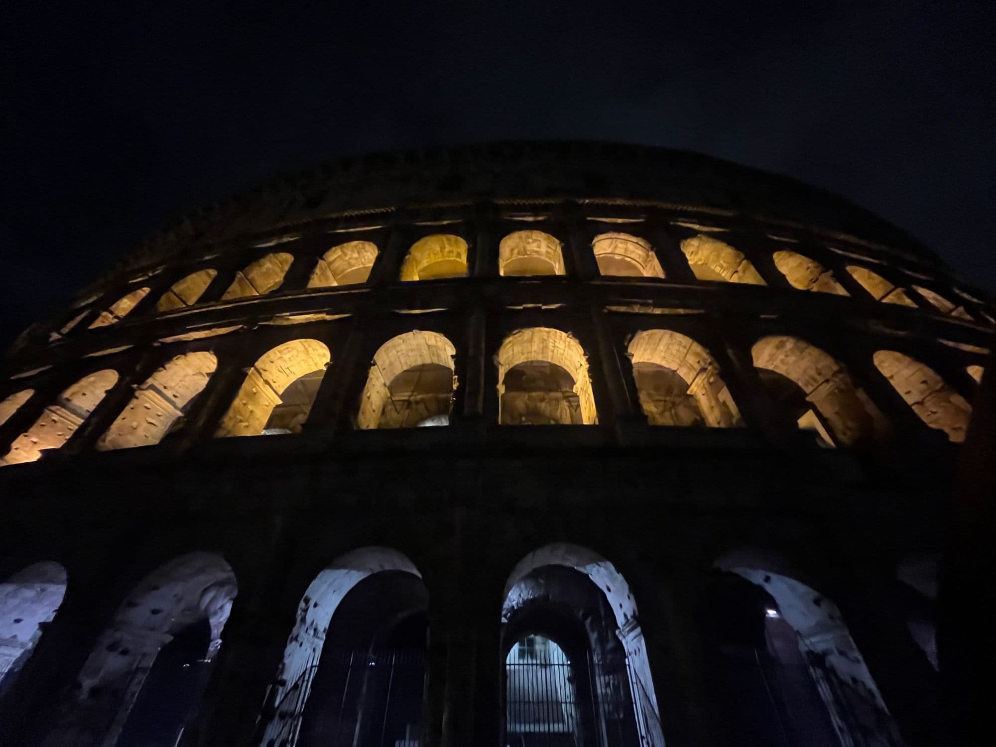 The Colosseum’s arches lit gold against the night sky.