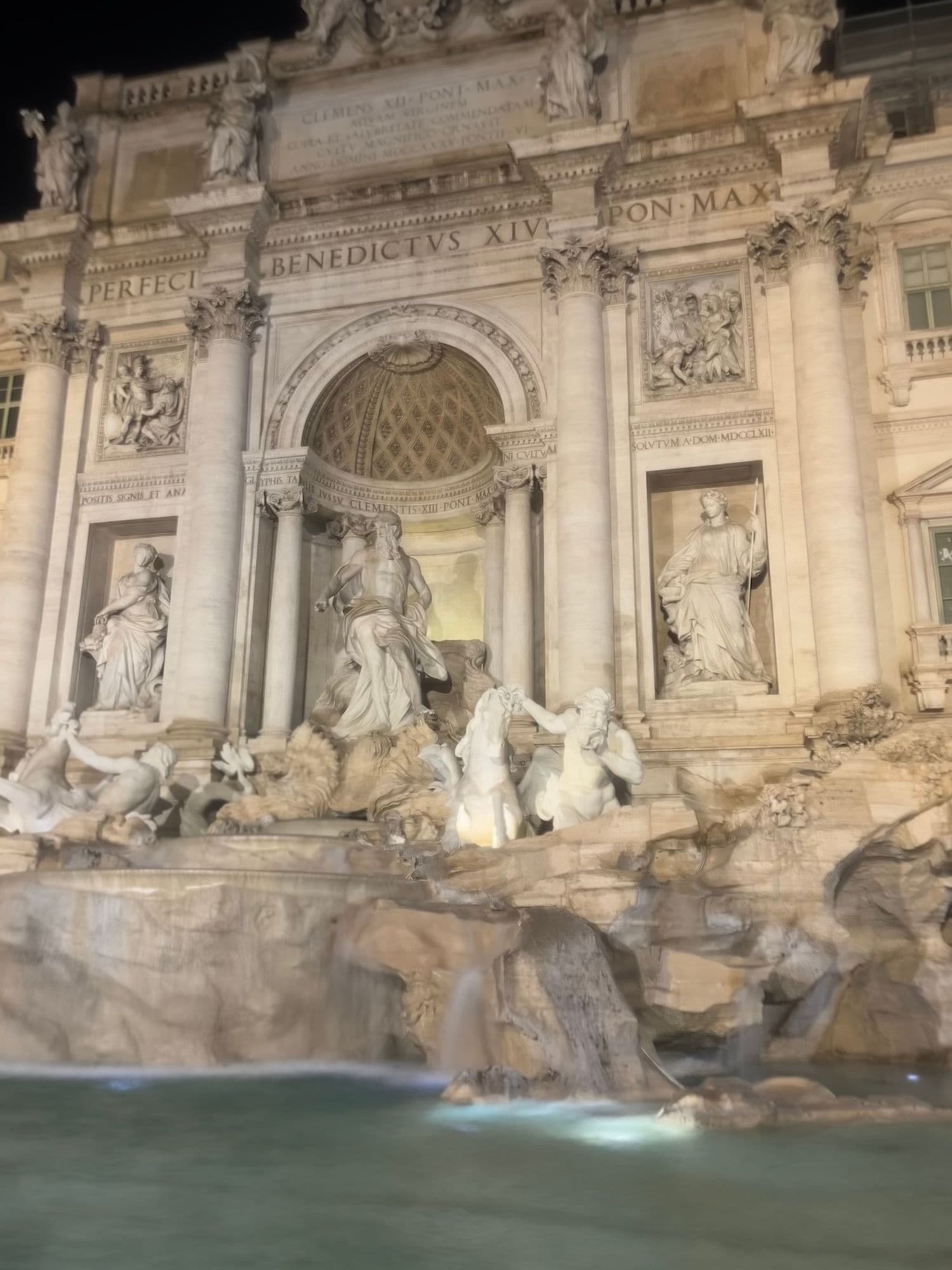 The Trevi Fountain lit up at night.